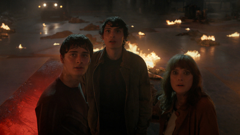 Will, Mike, and Joyce look up at something in Stranger Things