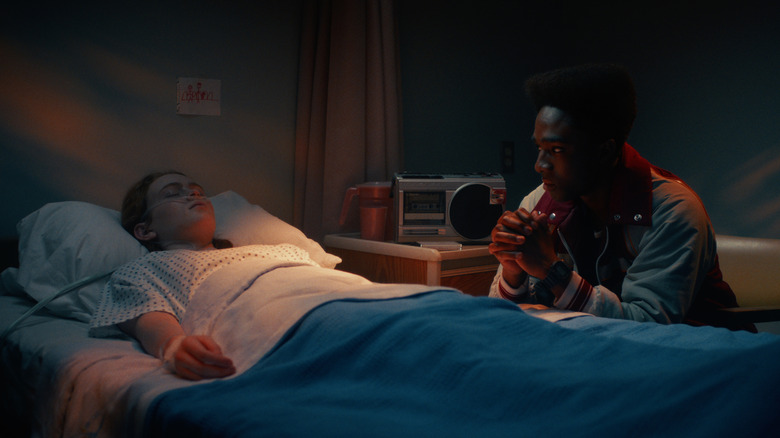 Lucas sitting by Max's bedside in Stranger Things season 5