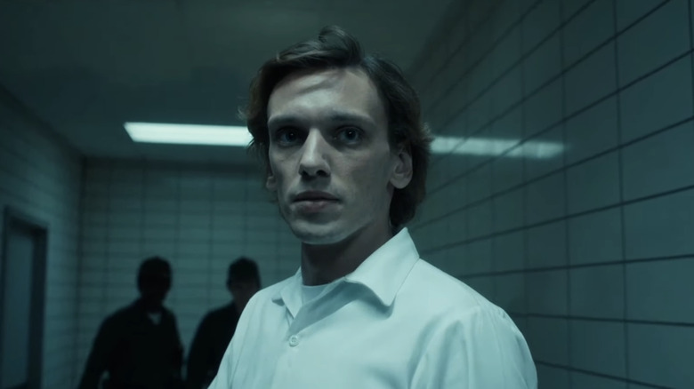 ஜேமி கேம்ப்பெல் போவரின் ஹென்றி க்ரீல் ஸ்ட்ரேஞ்சர் திங்ஸில் ஒரு நடைபாதையில் நிற்கிறார்