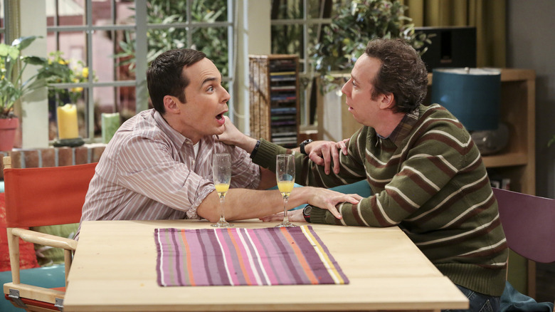 Sheldon and Stuart drinking mimosas and grabbing each other's arms on The Big Bang Theory