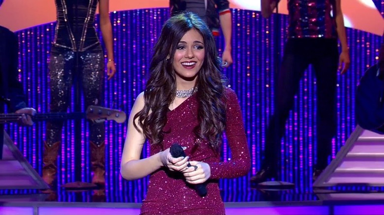 Tori Vega smiling and holding a microphone on "Victorious"