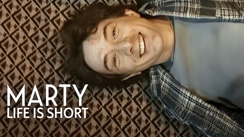 Martin Short laying sideways on a carpet