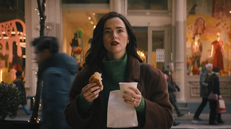 Rachel holding a coffee and bread in the street in New York in Something From Tiffany's