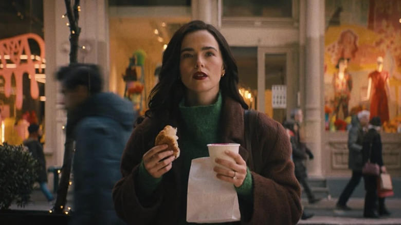 Rachel holding a coffee and bread in the street in New York in Something From Tiffany's