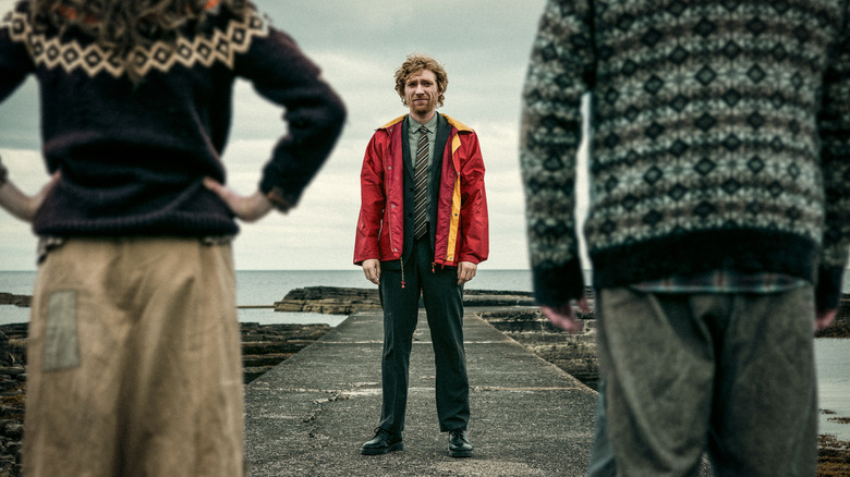 Domhnall Gleeson as Daniel, standing on a dock facing a brother and sister in The Incomer