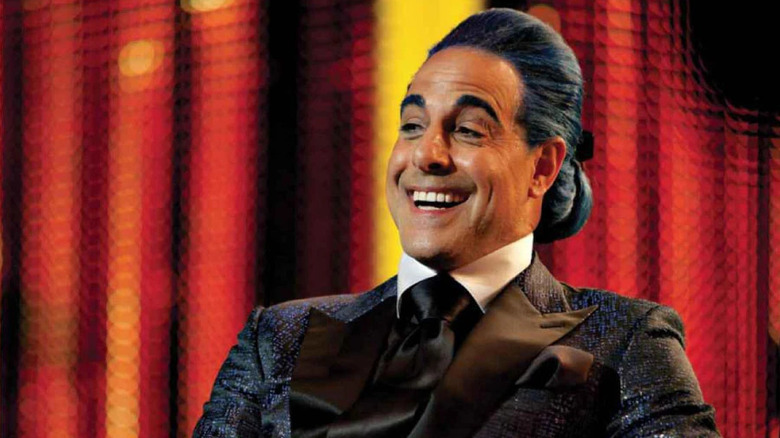 Caesar with blue hair and suit smiling in The Hunger Games