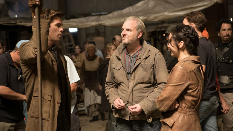 Francis Lawrence chatting with Liam Hemsworth and Jennifer Lawrence on the set of The Hunger Games: Catching Fire