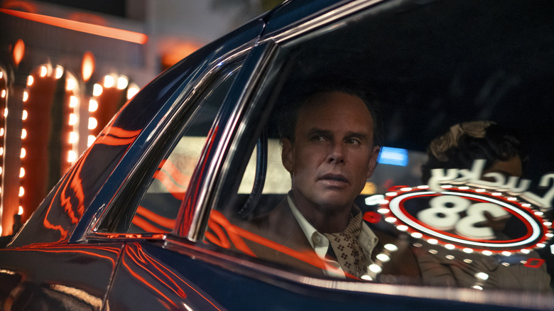 Cooper in a suit in a car driving through Vegas in Fallout