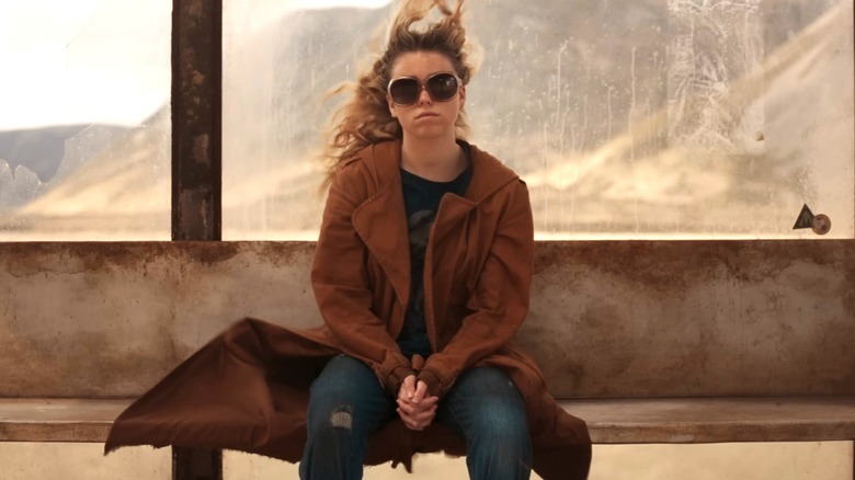 Milly Alcock as Kara Zor-El sitting at the bus stop in Supergirl