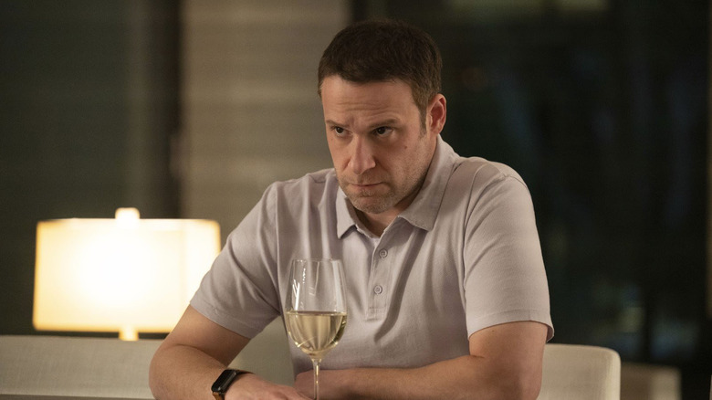 Seth Rogen as Gabe sitting at his bar top with a glass of wine in Dumb Money