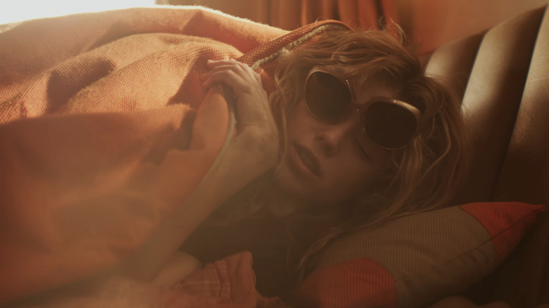 Milly Alcock als Kara met een zonnebril in bed in Supergirl (2026)