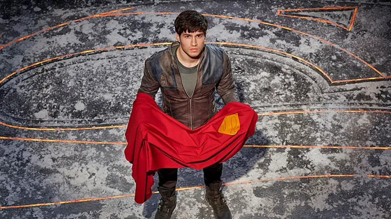 Cameron Cuffe as Seg-El, holding Superman's cape on the TV show Krypton