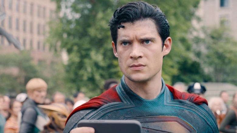 David Corenswet as Superman holding up a phone looking angry in Superman