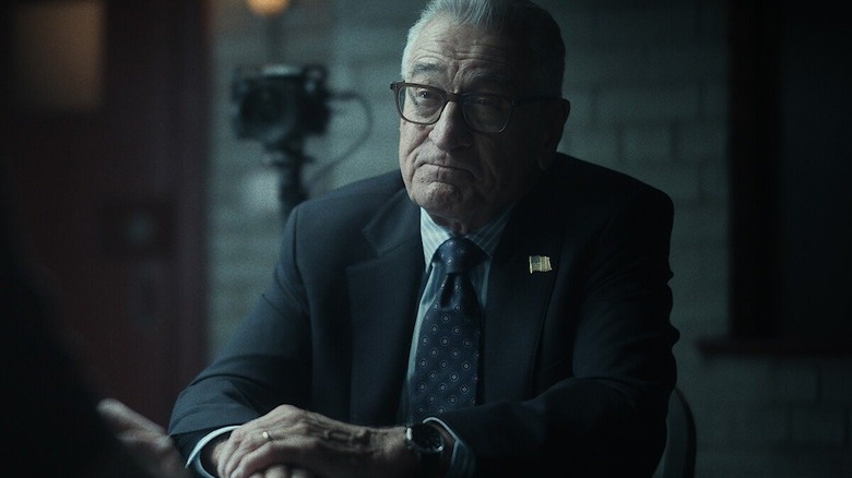Robert de Niro como George Mullen, sentado em uma sala de entrevista no drama da Netflix, Zero Day.