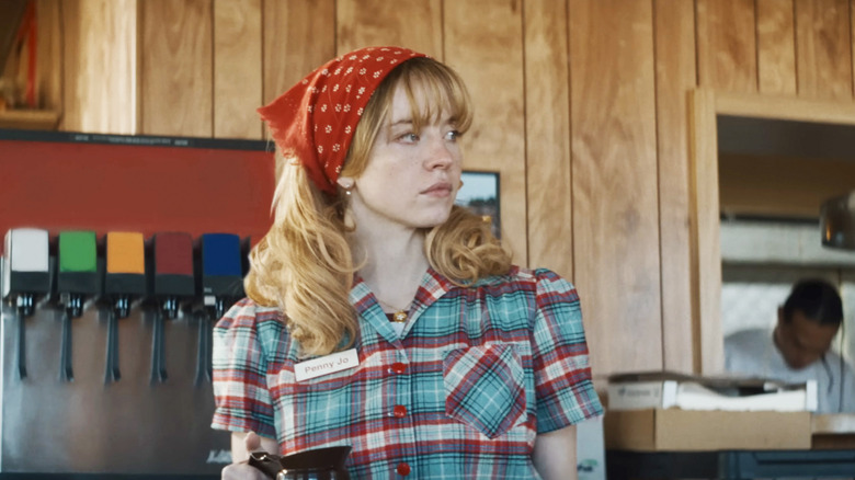 Sydney Sweeney's Penny Jo Poplin holds a pot of coffee as she stands behind the counter in a diner in Americana