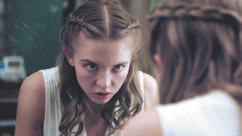 Juliet (Sydney Sweeney) olha para um espelho com a cabeça para baixo e os olhos para cima com uma expressão chocada em Nocturne
