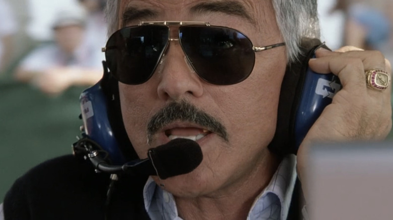 Burt Reynolds's Carl Henry talks on a headset in Driven