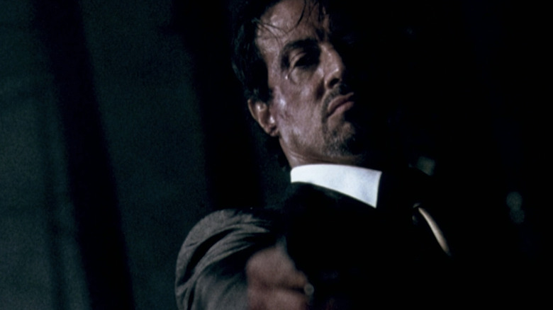 Sylvester Stallone's Jack Carter points a gun at camera in closeup in Get Carter