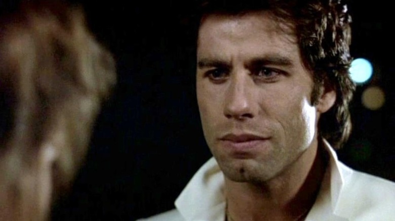 John Travolta listening intently as Tony Manero in Staying Alive