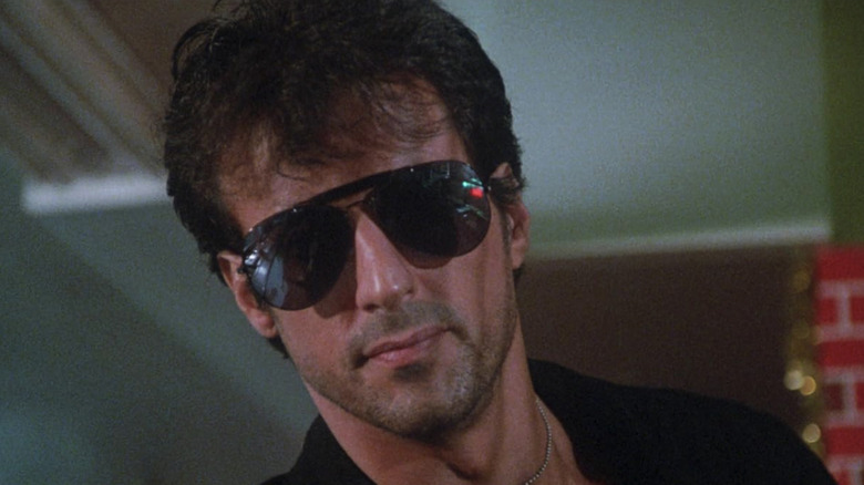 Sylvester Stallone as Marion Cobretti wearing sunglasses in Cobra