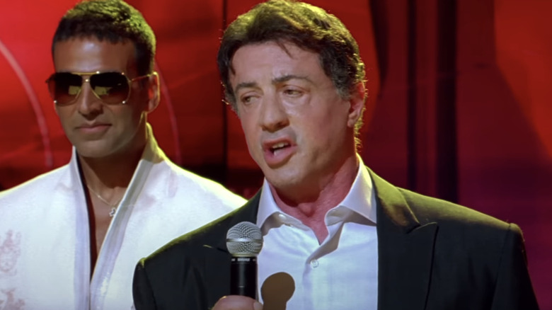 Akshay Kumar's Viraj Shergill stands behind Sylvester Stallone as he addresses an award ceremony in Kambakkht Ishq