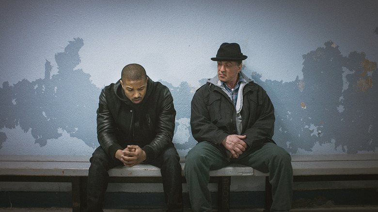 Adonis Creed (Michael B. Jordan) dan Rocky Balboa (Sylvester Stallone) duduk bersama di bangku di Creed