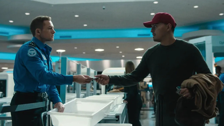 Taron Egerton as Ethan Kopek with a suspicious passenger in Carry-On