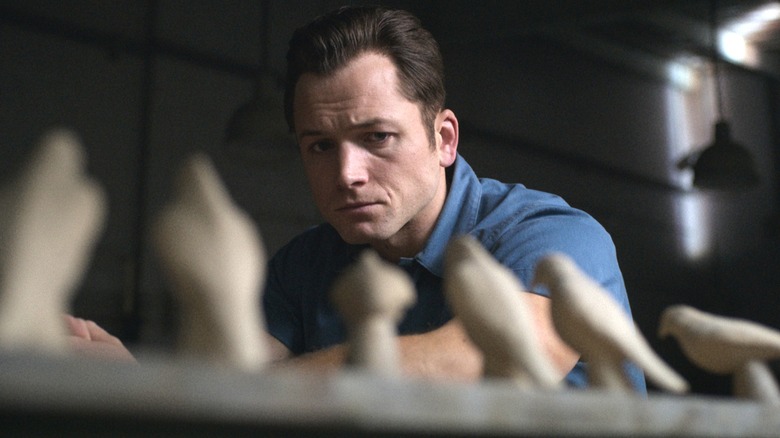 Taron Egerton as Jimmy in Black Bird looking at wooden bird carvings
