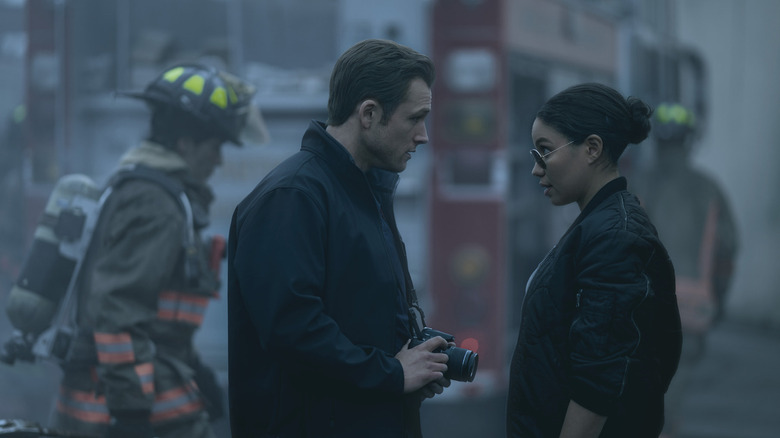 Dave Jodsen holds a camera while speaking to Detective Michelle Calderon in the middle of the deliberate crime scene in smoke