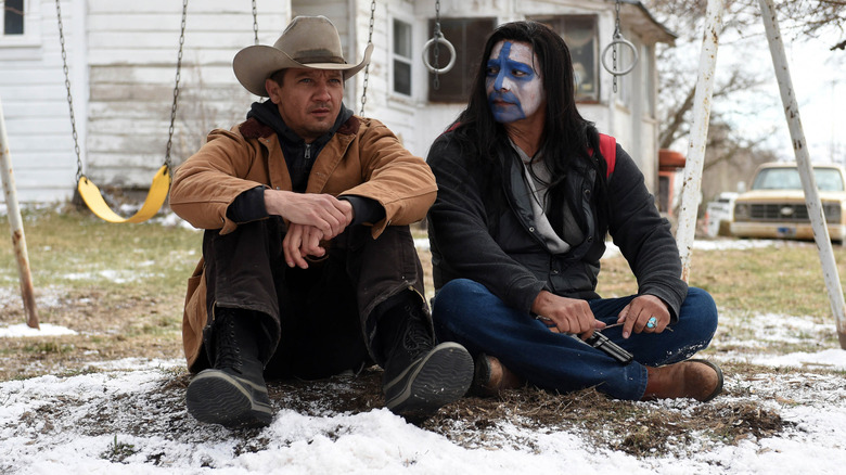 Jeremy Renner as Cory Lambert sitting with Gil Birmingham as Martin Hanson at the end of Wind River