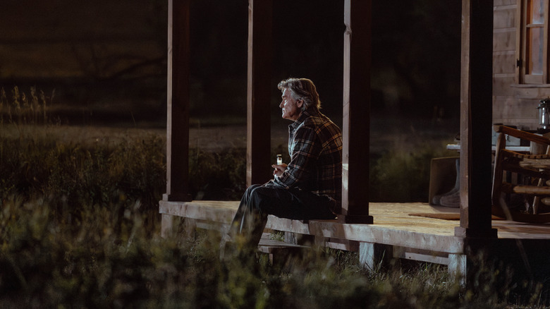 Kurt Russell as Preston Clyburn sitting on a porch with a drink in his hand in The Madison