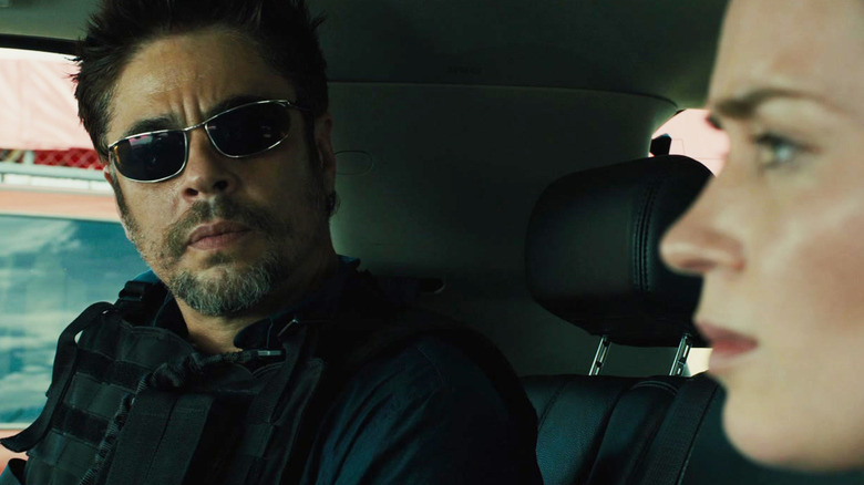 Emily Blunt's Kate Macer sits in a car alongside Benicio del Toro's Alejandro Gillick in Sicario