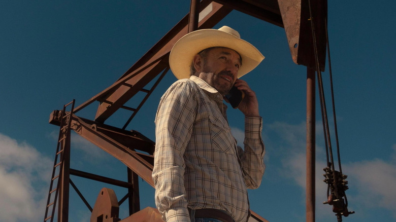 Billy Bob Thornton as Tommy Norris talking on the phone in front of an oil pump in Landman