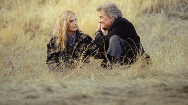 Stacy (Michelle Pfeiffer) and Preston (Kurt Russell) sitting in the grass on 
