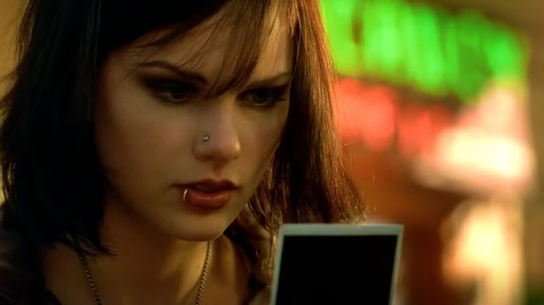 Haley with dark hair looking at a photograph on CSI