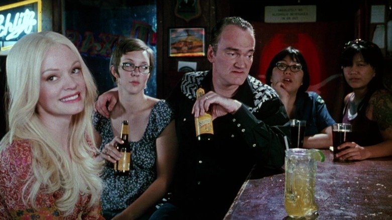 Warren with his arm around a female patron at his bar in Death Proof
