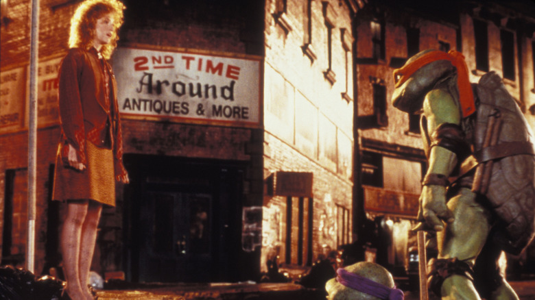 Judith Hoag's April O'Neal meeting Raph and Leo at a sewer drain in Teenage Mutant Ninja Turtles (1990)