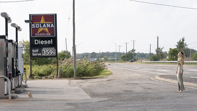 Lucy laughing at the gas station in a wide shot on Tell Me Lies