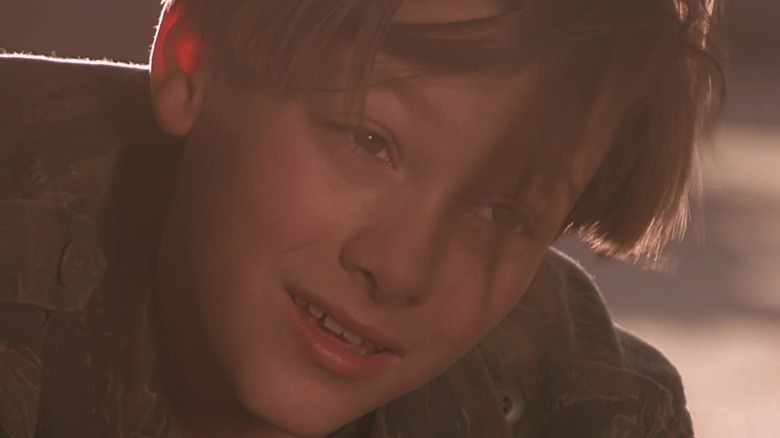 Edward Furlong's John Connor is seen in closeup as he looks under a car in Terminator 2 Judgmenet Day