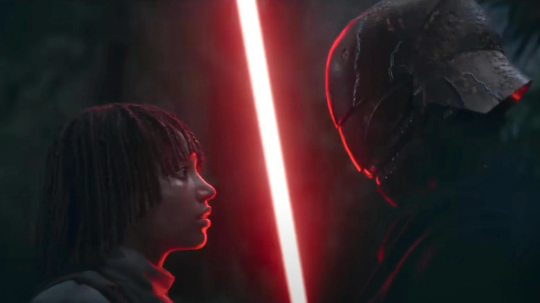 Mae stands in front of the villain and his red lightsaber in Star Wars: The Acolyte