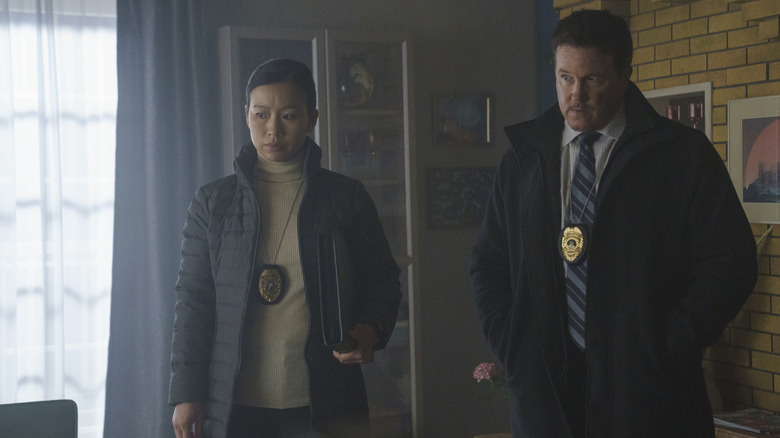 Annie Chang as Sophie Song and Lochlyn Munro as Larry Fitzgibbon standing around at a crime scene in Peacemaker season 1