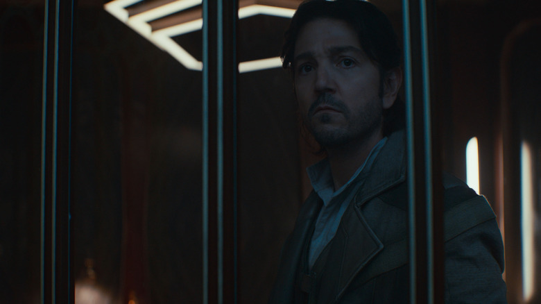 Diego Luna as Cassian Andor looking outside from behind a window in Andor