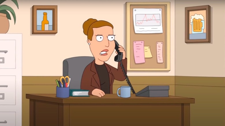 Angela sitting at desk while on the phone