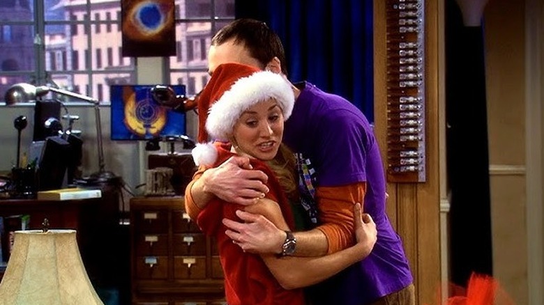 Sheldon hugging Penny in a Santa hat on The Big Bang Theory