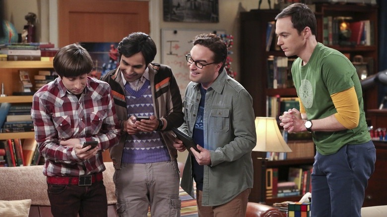 Howard, Raj, Leonard, and Sheldon looking at Howard's phone excitedly on The Big Bang Theory