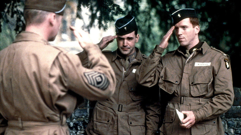 Damian Lewis as Major Richard Winters and Ron Livingston as Captain Lewis Nixon salute another soldier in Band of Brothers