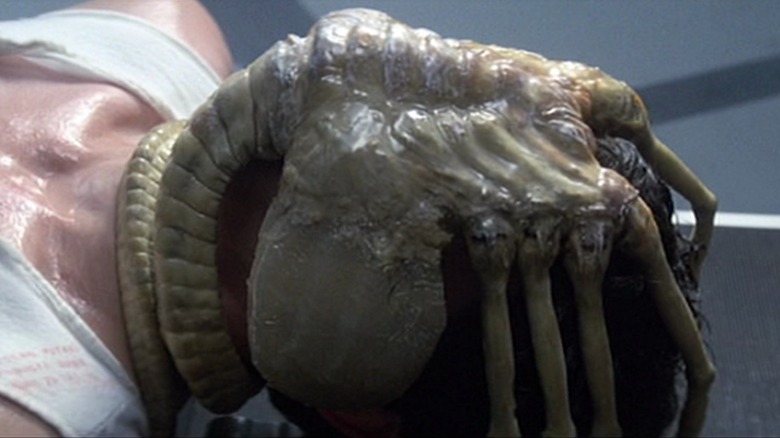 A face-hugger alien covering someone's face, in Alien