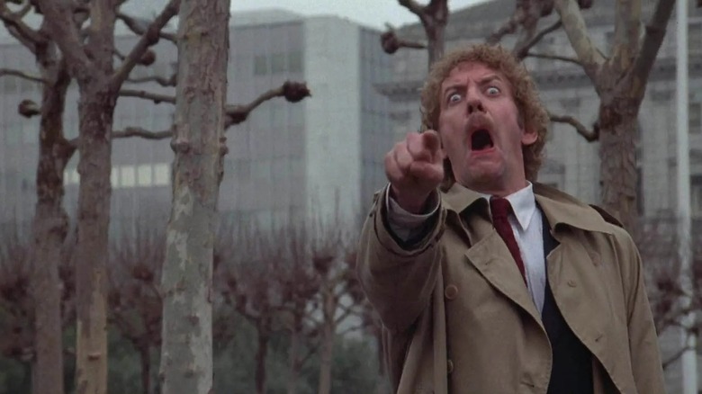 Donald Sutherland as Matthew, mouth hanging open in horror as he points, in Invasion of the Body Snatchers