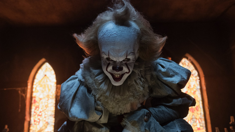 Bill Skarsgard as Pennywise smiling menacingly in It: Chapter One
