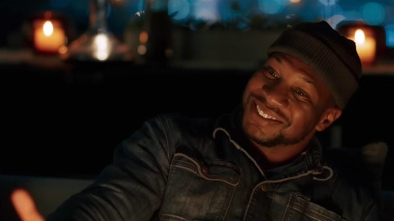 Jonathan Majors smiling firelight